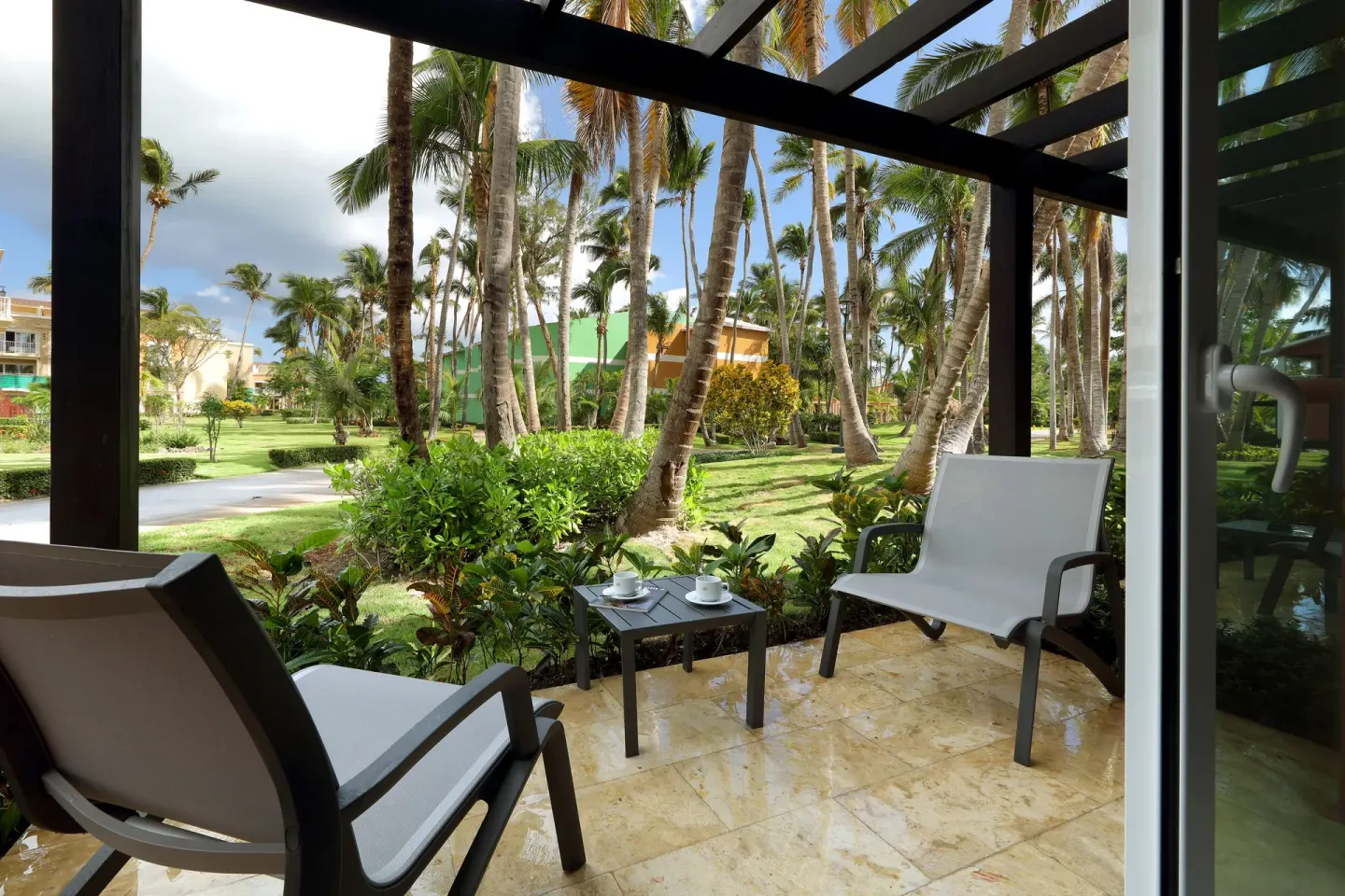 Terrace with chairs facing tropical gardens at Grand Palladium Punta Cana Resort & Spa.