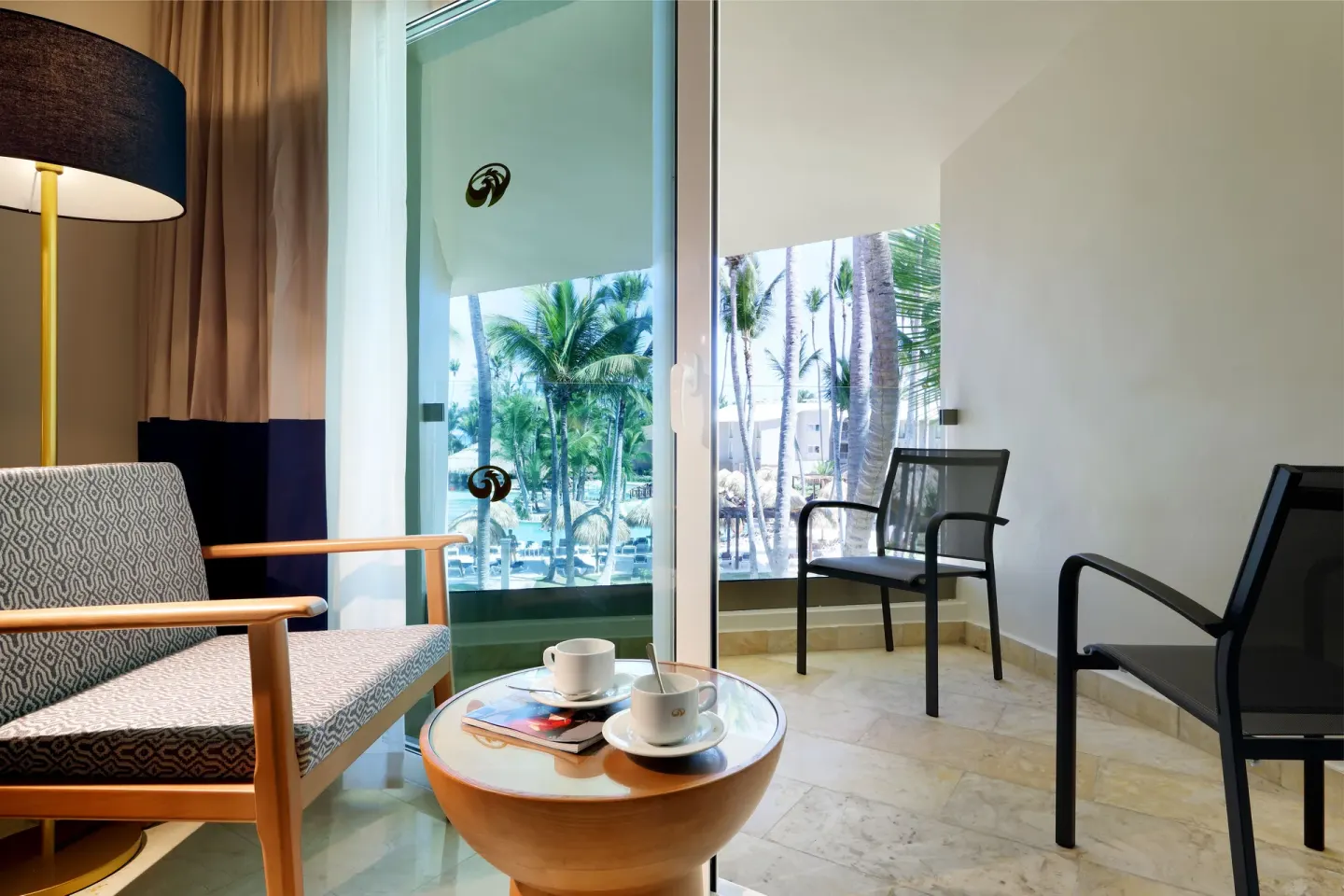 Guest room sitting area and balcony chairs at Grand Palladium Punta Cana Resort & Spa.