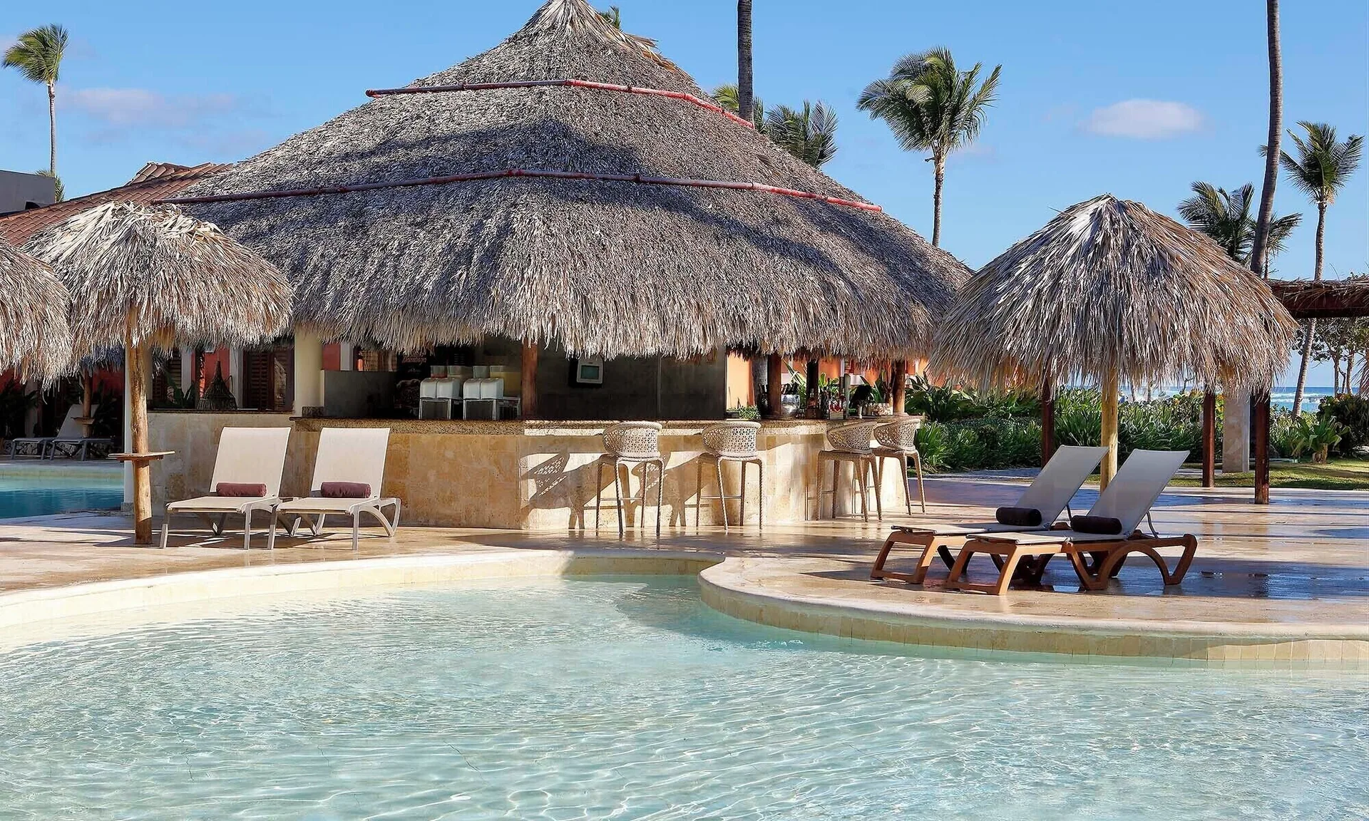 Poolside swim-up bar with thatched roofs at Grand Palladium Punta Cana Resort & Spa.