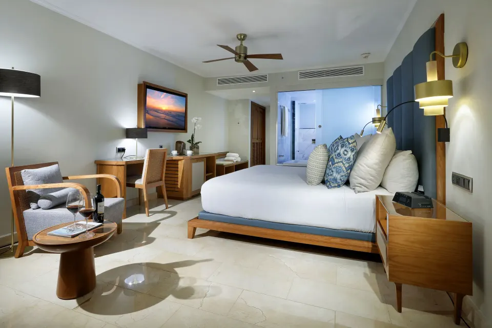 Deluxe Garden View king room with armchair and small table at Grand Palladium Punta Cana Resort & Spa.