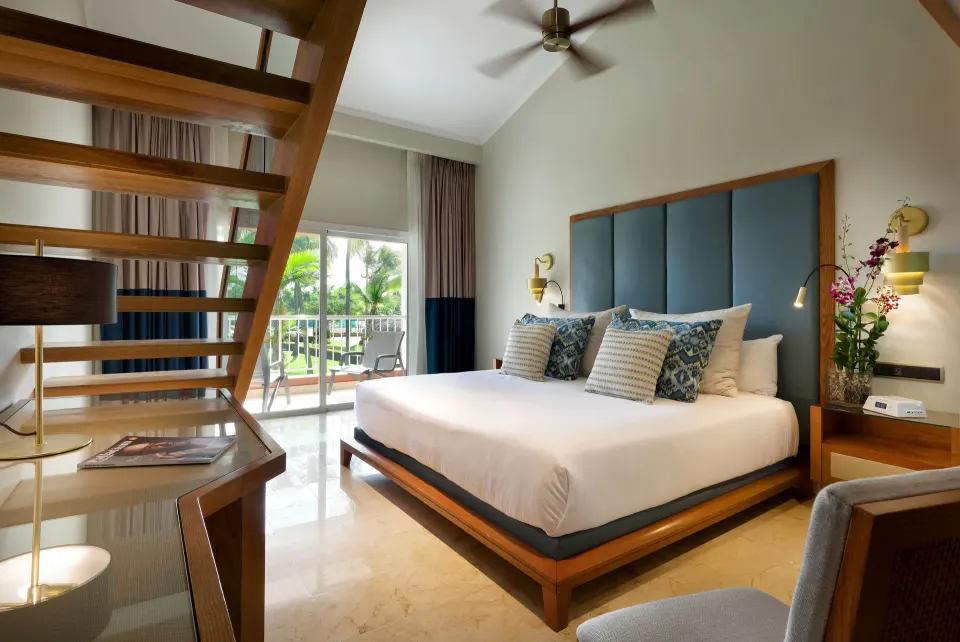 Loft Suite Garden View king bed and balcony doors at Grand Palladium Punta Cana Resort & Spa.