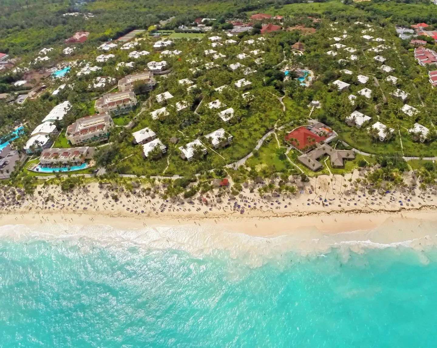 Aerial view of the beach, turquoise water, and resort grounds at Grand Palladium Select Bávaro.