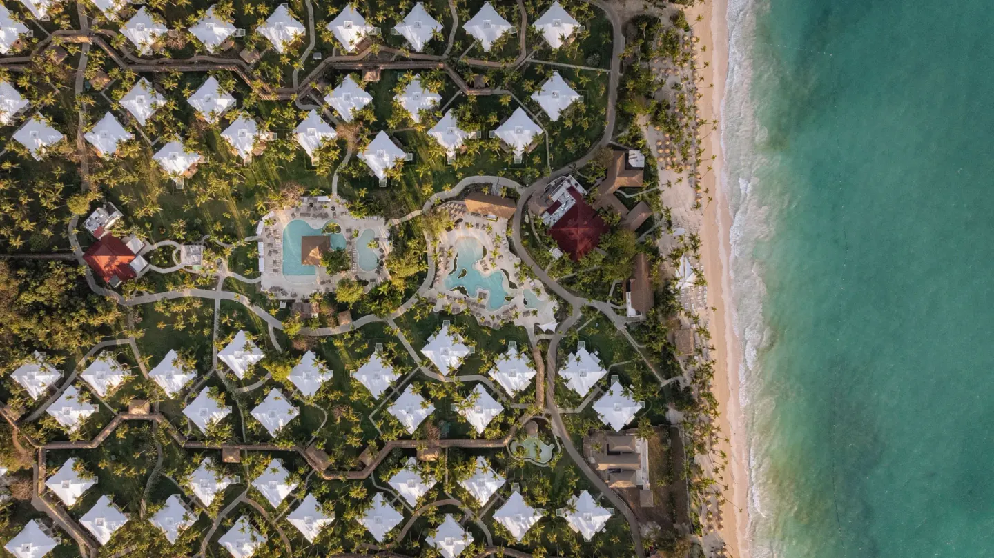 Aerial view of resort buildings, pools, beach, and ocean at Grand Palladium Select Bávaro.