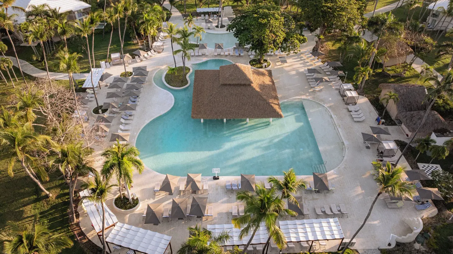 Aerial view of a palm-lined resort pool at Grand Palladium Select Bávaro.