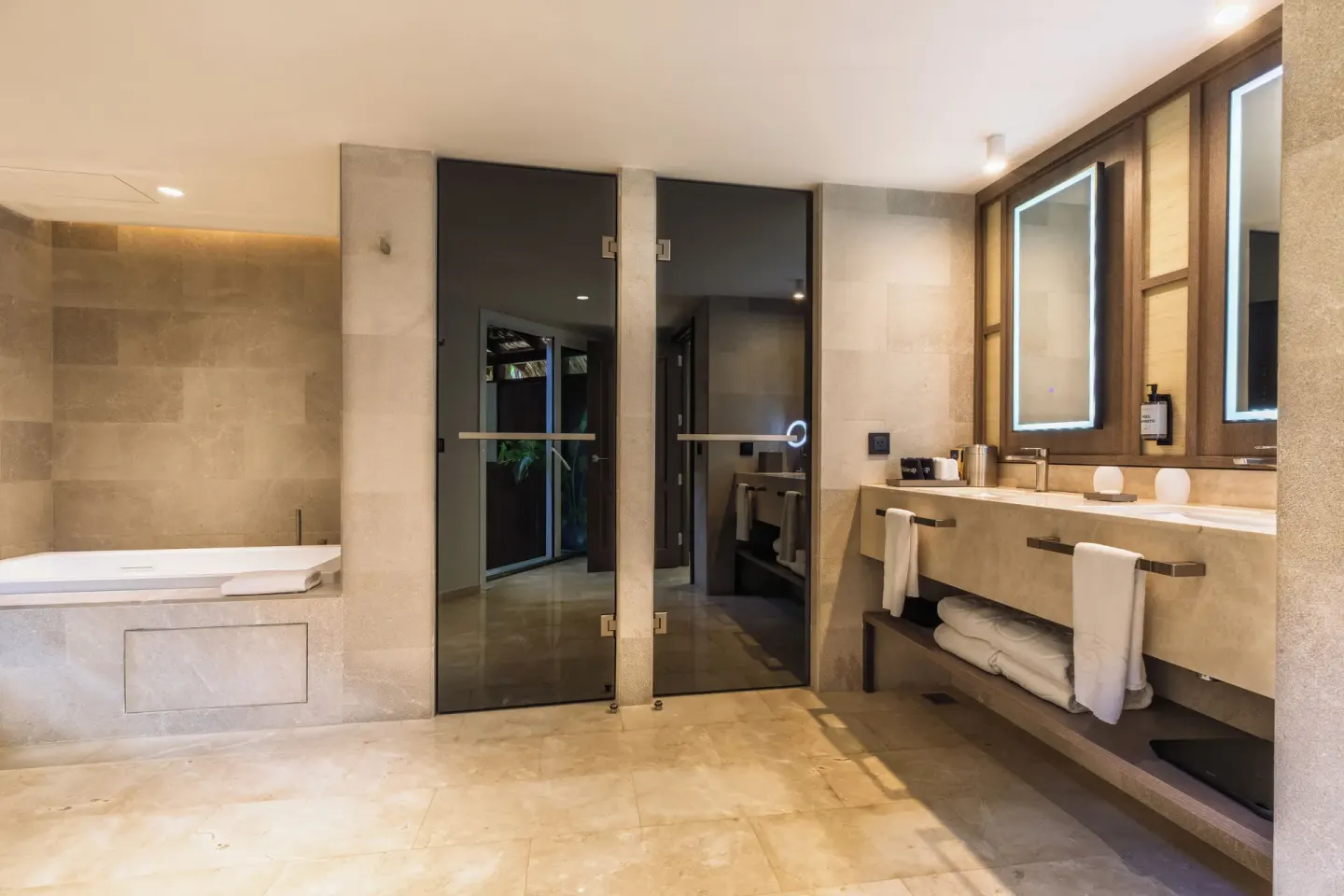 Bathroom with soaking tub, glass shower doors, and double vanity at Grand Palladium Select Bávaro.