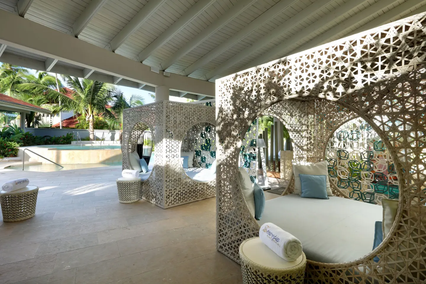 Covered lounge with woven cabana daybeds at Grand Palladium Select Bávaro.