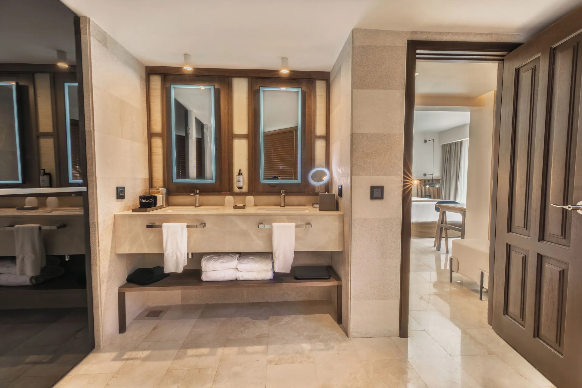 Double vanity bathroom with illuminated mirrors at Grand Palladium Select Bávaro.