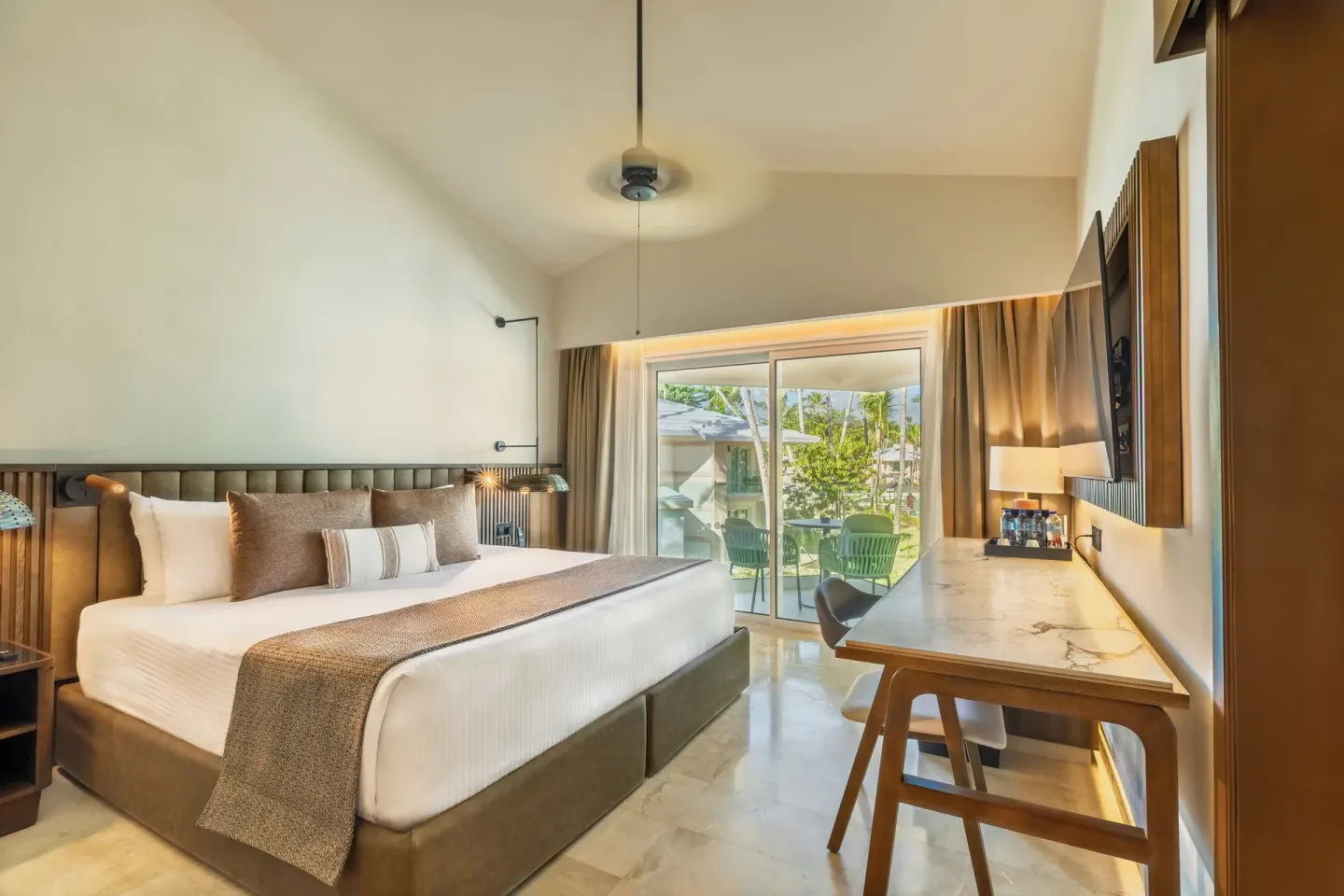 King bed guest room with desk and balcony at Grand Palladium Select Bávaro.