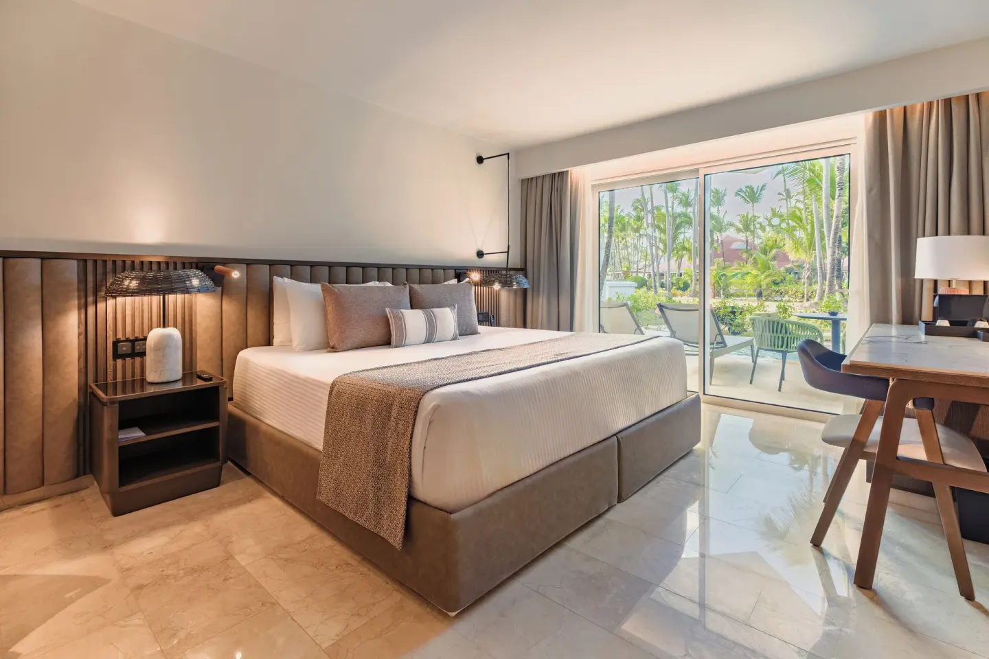 King bed guest room with garden-facing patio at Grand Palladium Select Bávaro.