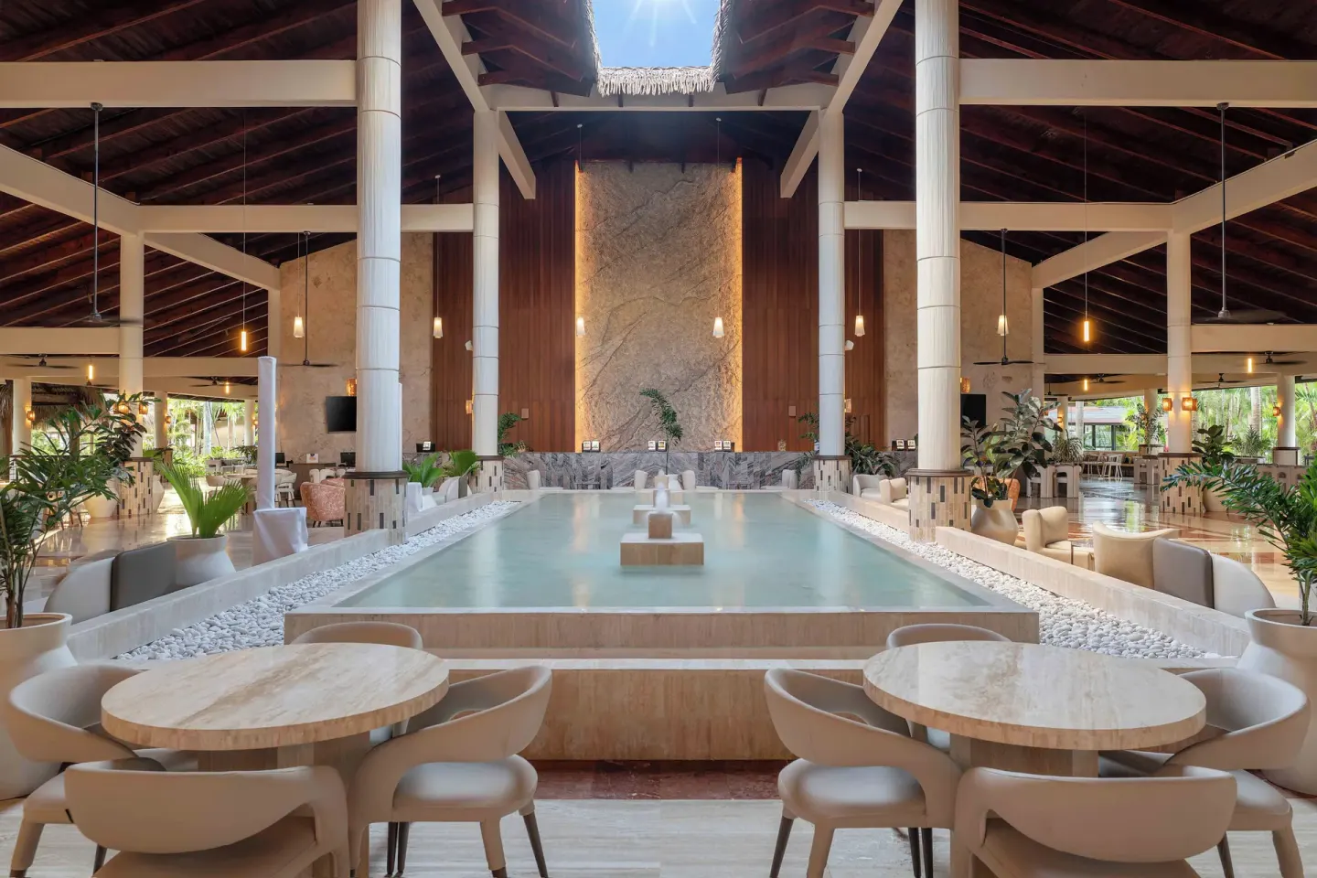 Open-air lobby lounge with reflecting pool at Grand Palladium Select Bávaro.