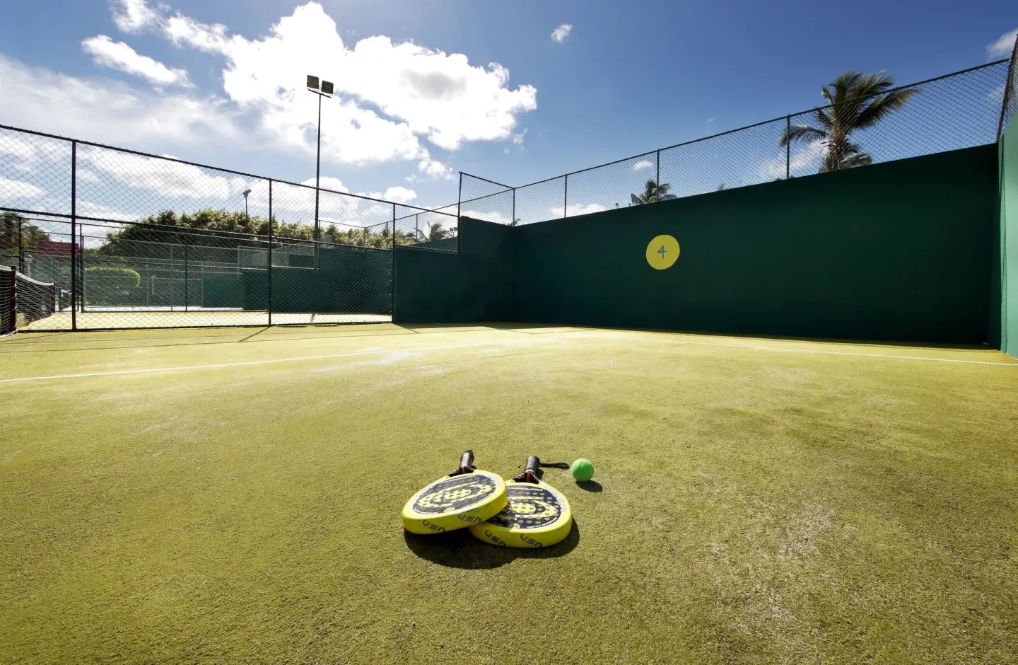 Paddle court with rackets and ball on the turf at Grand Palladium Select Bávaro.