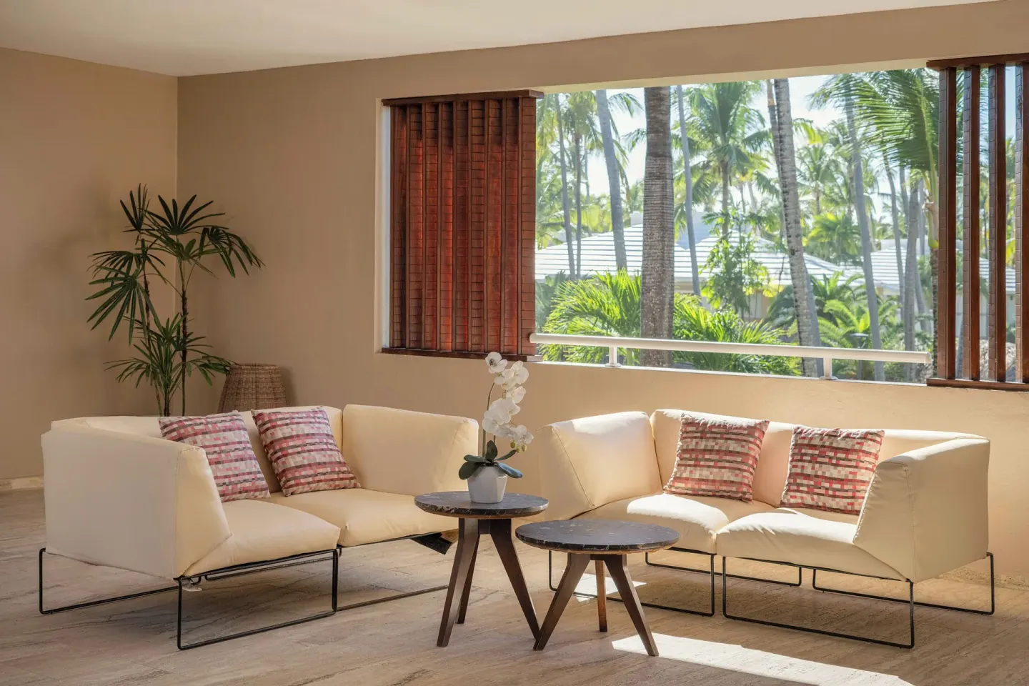 Junior Suite Beachside sitting area with sofas and palm views at Grand Palladium Select Bávaro.