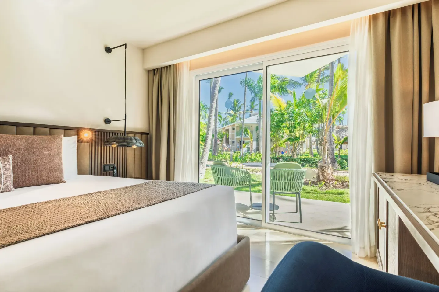 Junior Suite Garden View king bed opening to garden patio at Grand Palladium Select Bávaro.