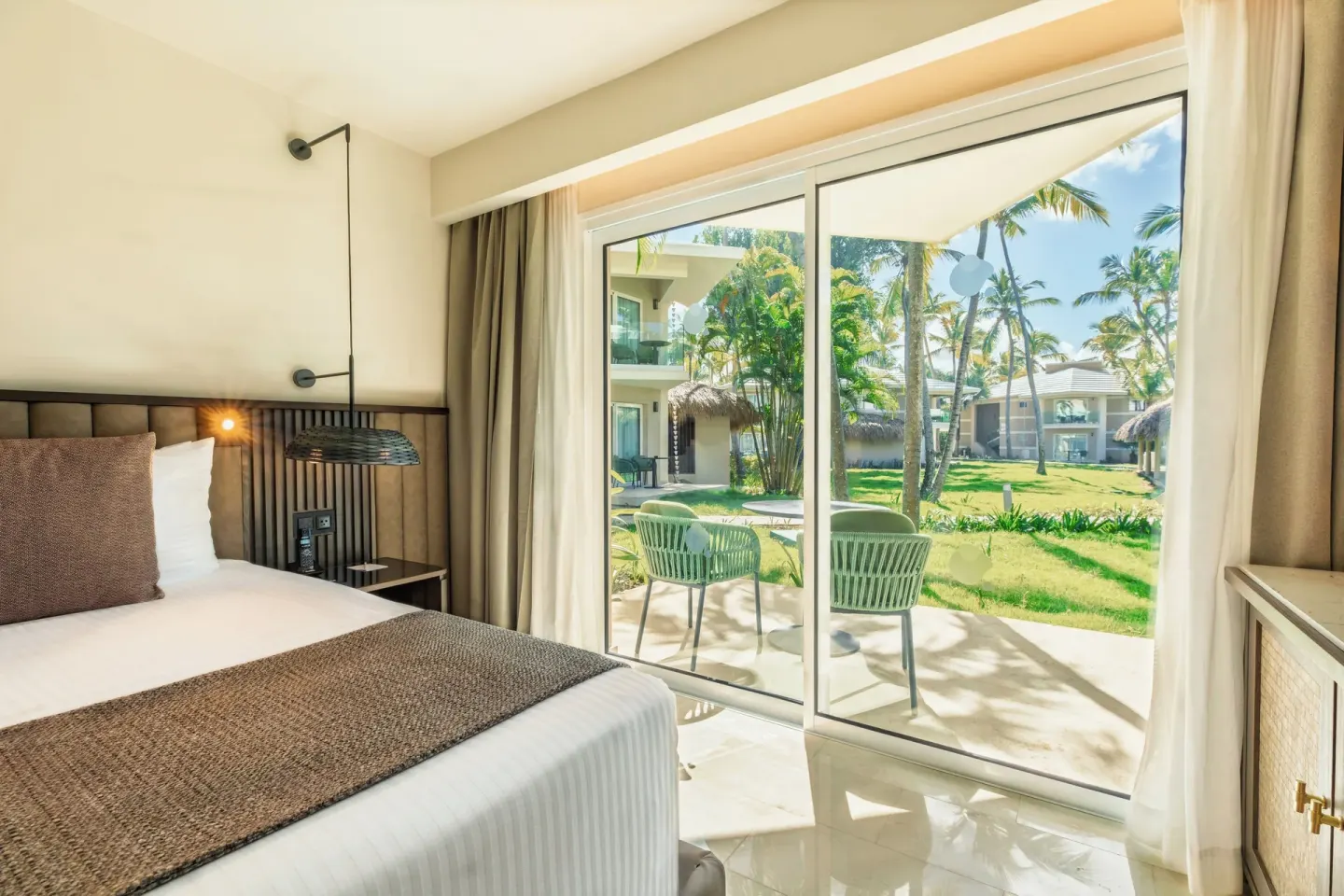 Romance Suite Garden View king bed and patio doors at Grand Palladium Select Bávaro.