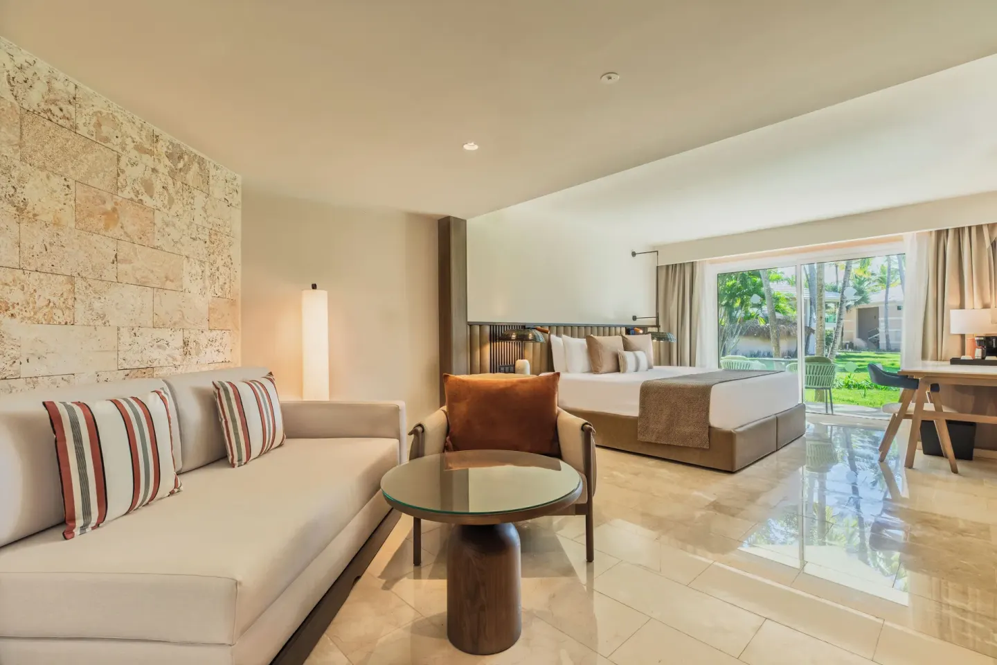 Romance Suite Garden View sitting area and king bed at Grand Palladium Select Bávaro.