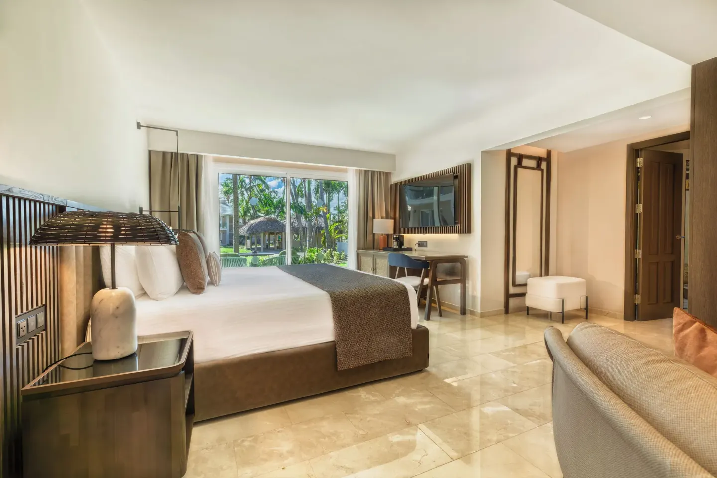 Romance Suite Garden View bedroom with TV and garden doors at Grand Palladium Select Bávaro.