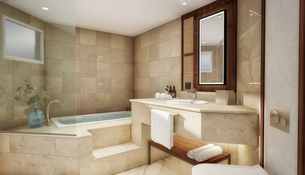Junior Suite bathroom with soaking tub, vanity, and mirror at Grand Palladium Select Bávaro.