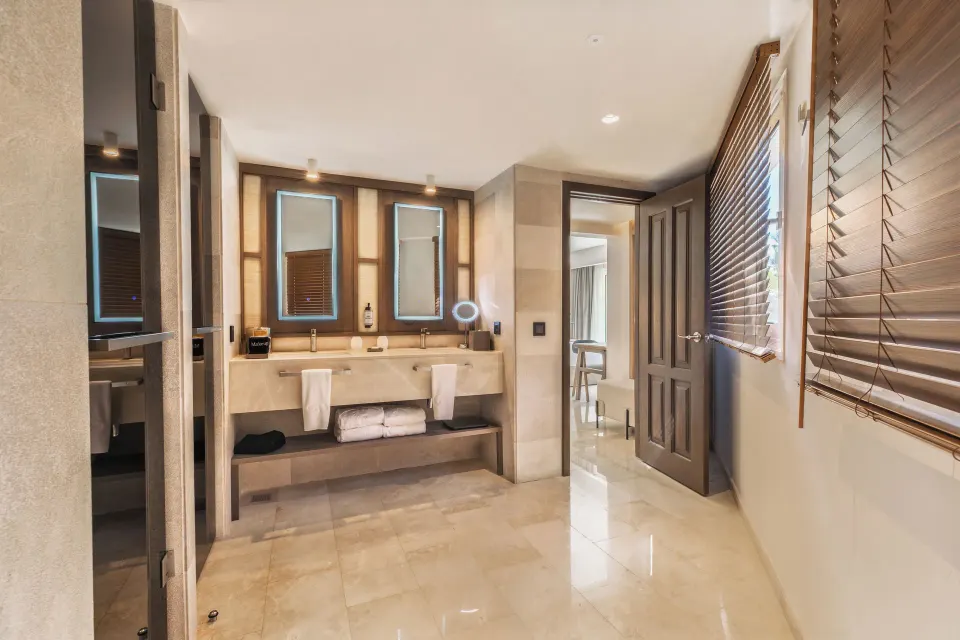 Superior Junior Suite Garden View bathroom at Grand Palladium Select Bávaro with double vanity and wood blinds.