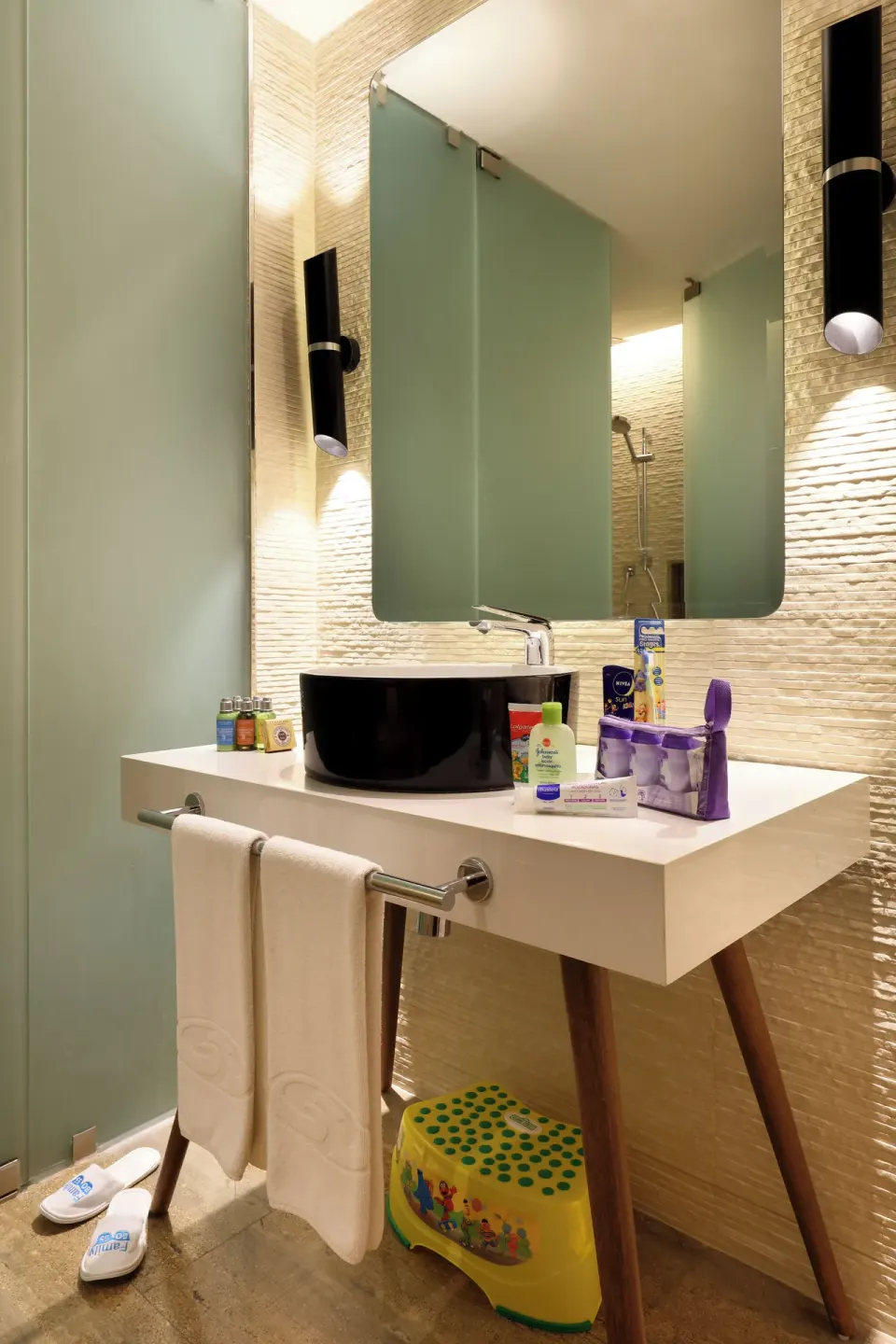 Bathroom vanity with black basin and child step stool at Grand Palladium Select Costa Mujeres.