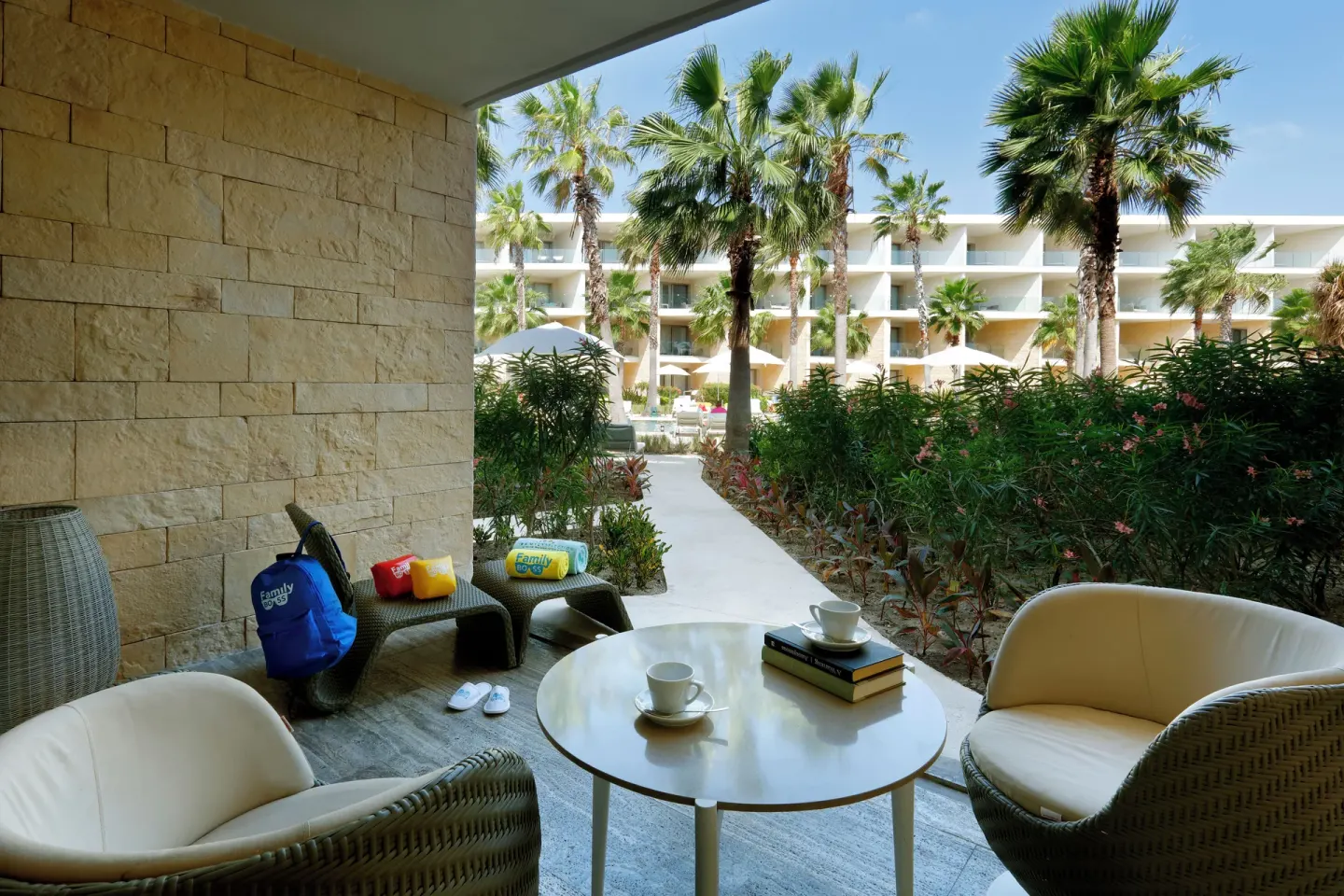 Garden-level terrace with seating and palm-lined resort view at Grand Palladium Select Costa Mujeres.