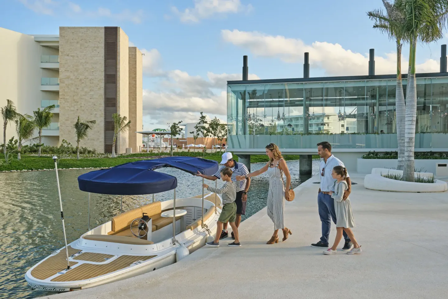 Family boarding a small boat on the lagoon at Grand Palladium Select Costa Mujeres.