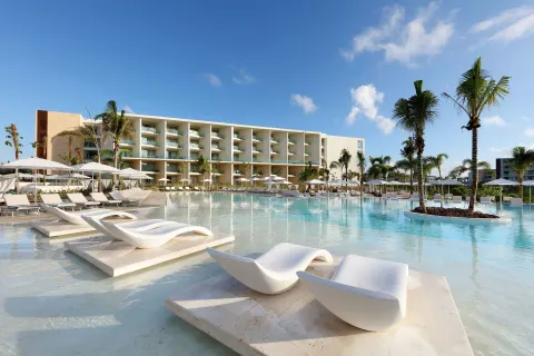 Large resort pool with in-water loungers at Grand Palladium Select Costa Mujeres.