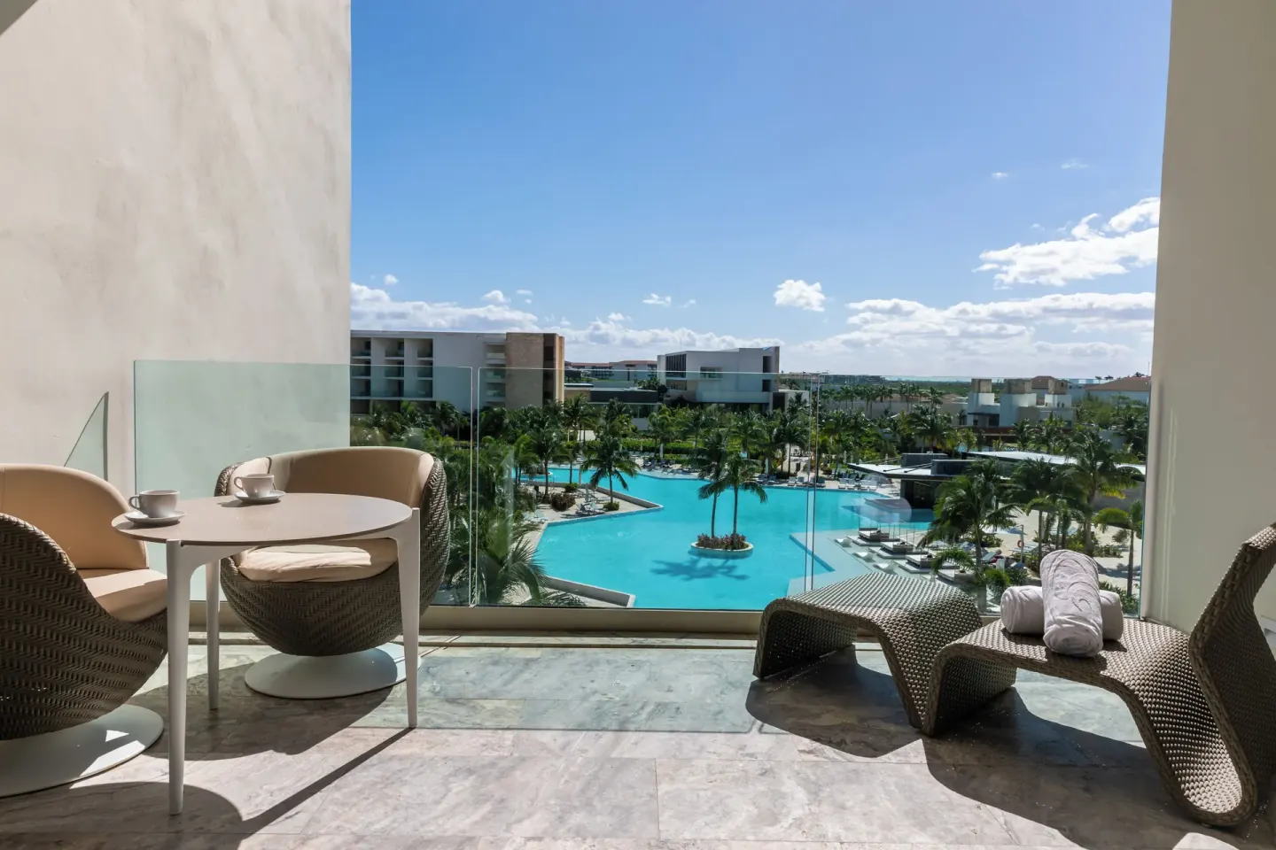 Junior Suite Poolside balcony with seating and pool view at Grand Palladium Select Costa Mujeres.