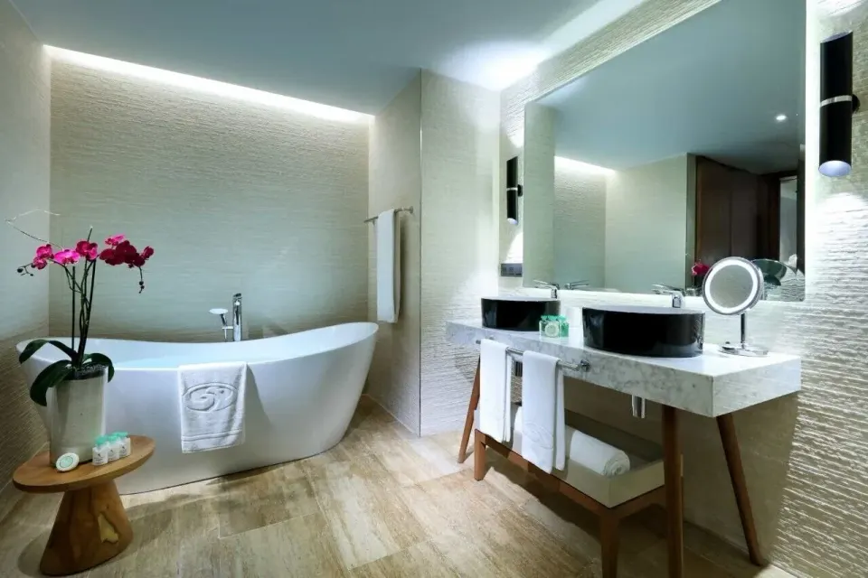 Junior Suite bathroom with freestanding tub and double vanity at Grand Palladium Select Costa Mujeres.