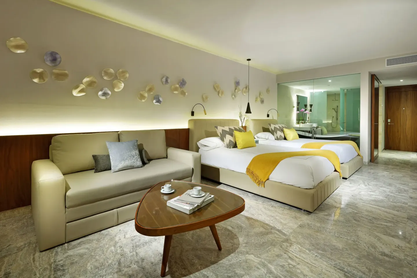 Junior Suite with two beds, sofa, and open bath at Grand Palladium Select Costa Mujeres.