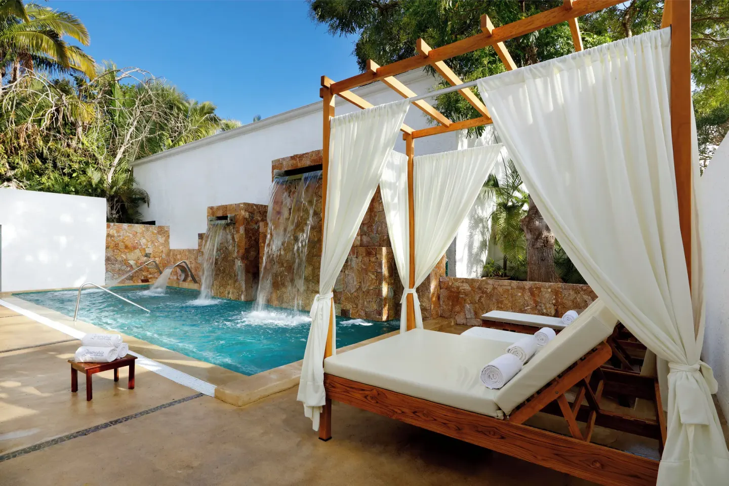 Canopied spa lounger beside a waterfall pool at Grand Palladium Vallarta Resort & Spa.