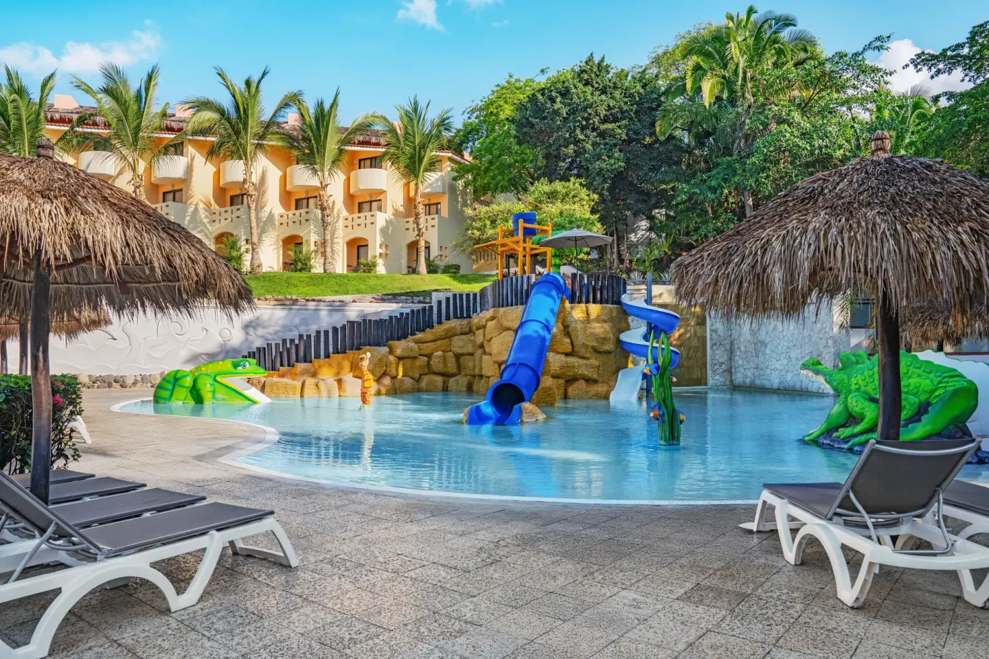 Kids’ splash pool with slides, loungers and palapa shade at Grand Palladium Vallarta Resort & Spa.