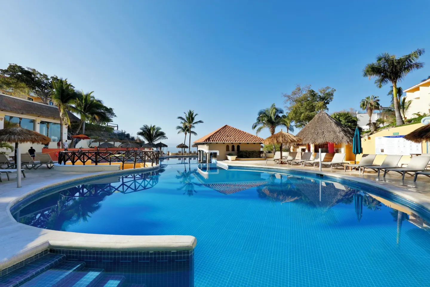 Main pool with loungers and palms at Grand Palladium Vallarta Resort & Spa.