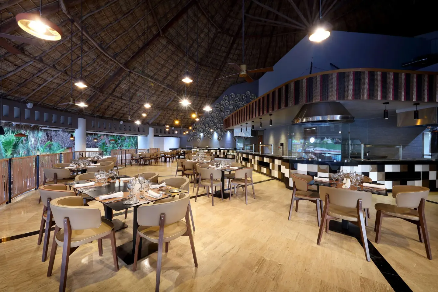 Open-air restaurant dining room at Grand Palladium Vallarta Resort & Spa with set tables and buffet counters.