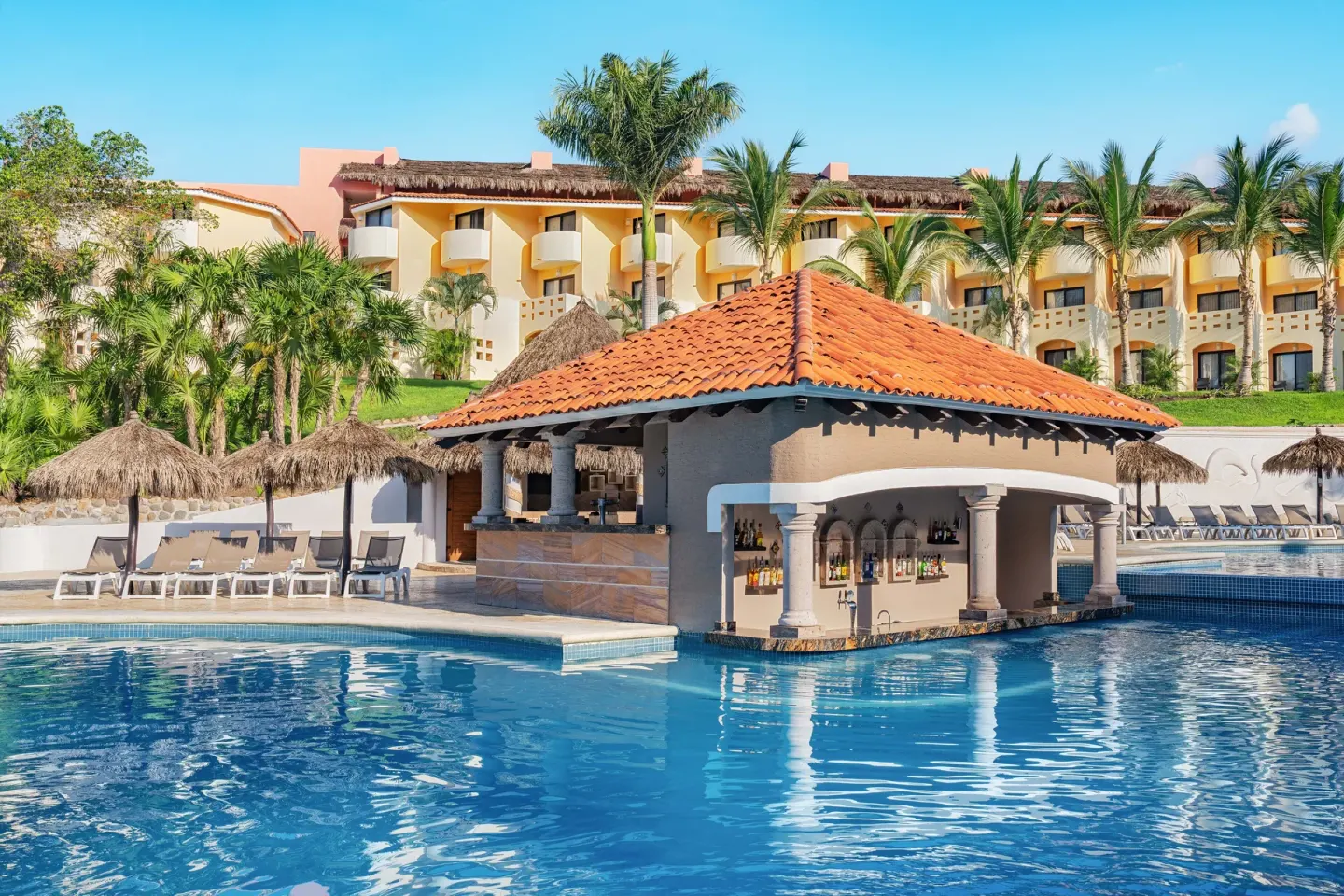 Swim-up pool bar and loungers at Grand Palladium Vallarta Resort & Spa.