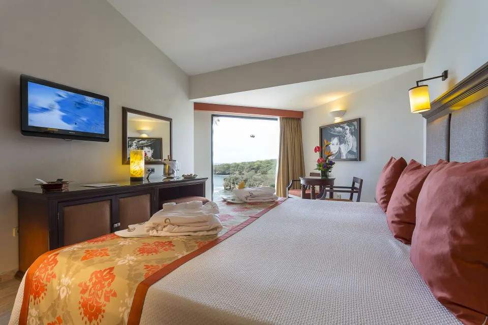 Deluxe Ocean View king room with robes on the bed at Grand Palladium Vallarta Resort & Spa.