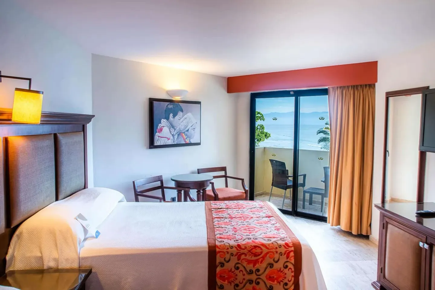 Deluxe Suite Ocean View king bed and balcony doors at Grand Palladium Vallarta Resort & Spa.