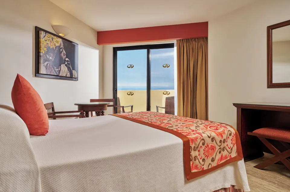 Deluxe Suite Ocean View bed and balcony at Grand Palladium Vallarta Resort & Spa.