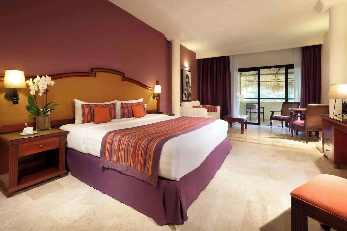 Family Selection Junior Suite king bed with balcony doors beyond at Grand Palladium Vallarta Resort & Spa.