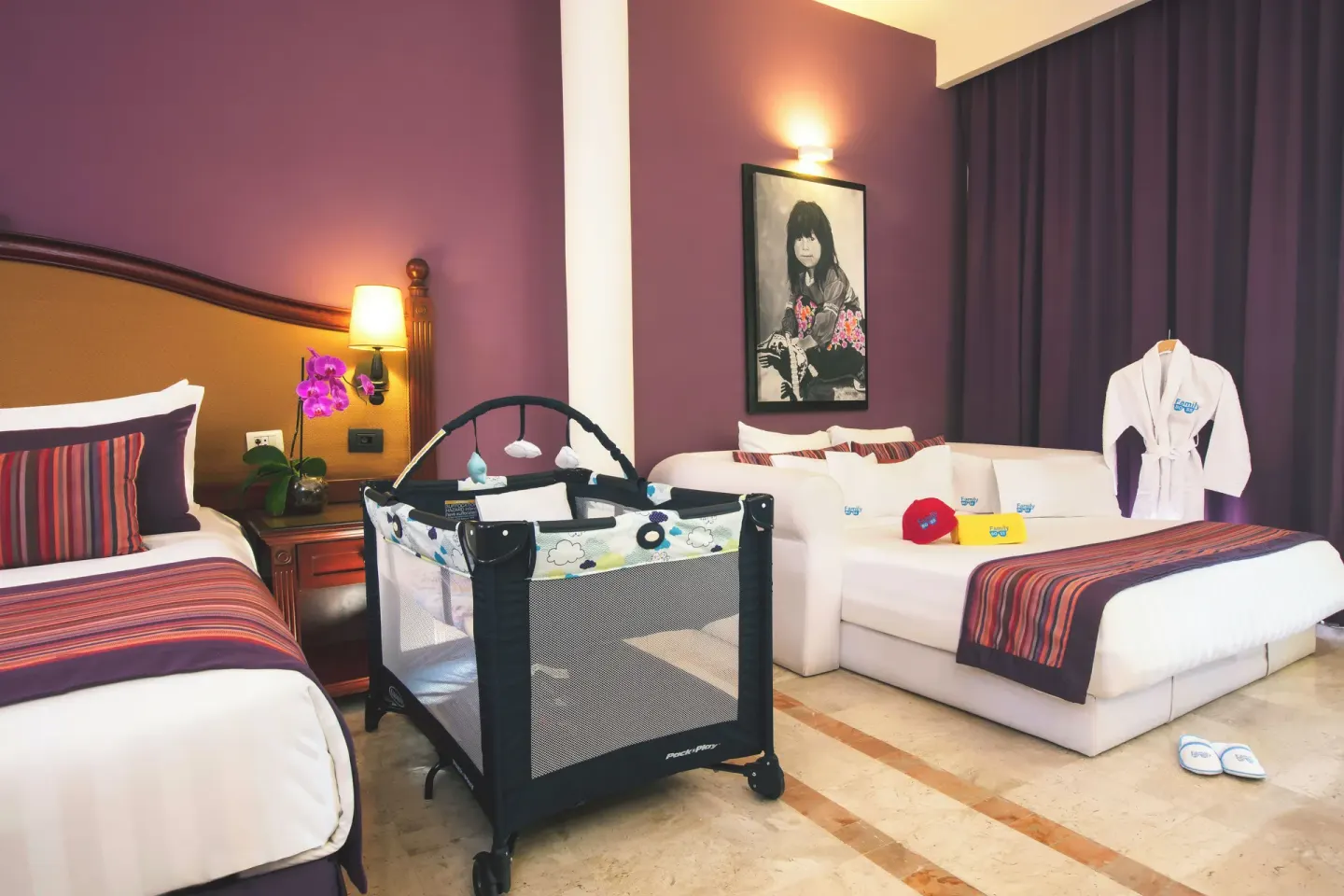 Family Selection Junior Suite with bed, crib, sofa, and child robe at Grand Palladium Vallarta Resort & Spa.