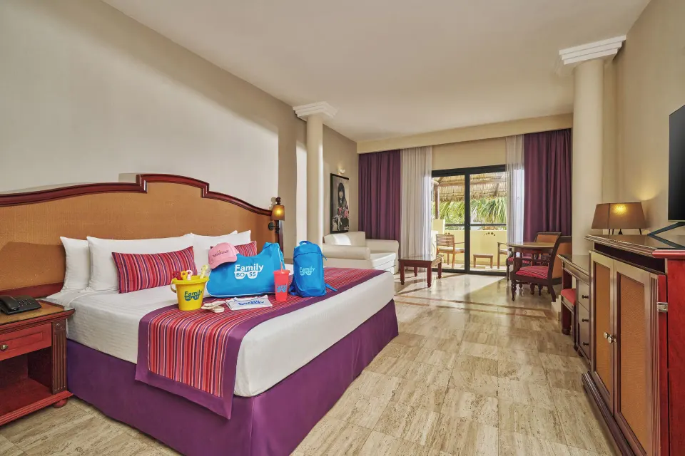 Family Selection Junior Suite king bed with sitting area and balcony at Grand Palladium Vallarta Resort & Spa.