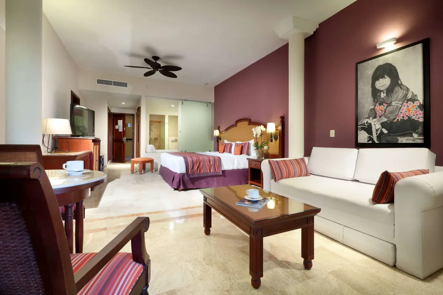 Family Selection Junior Suite with king bed, sofa, TV, and dining table at Grand Palladium Vallarta Resort & Spa.