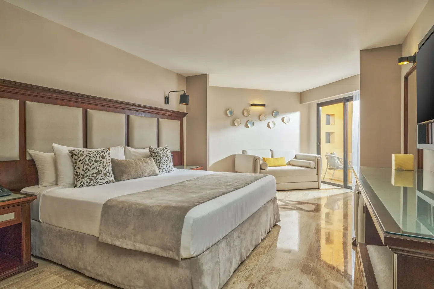 Junior Suite king bed with sofa and balcony doors at Grand Palladium Vallarta Resort & Spa.