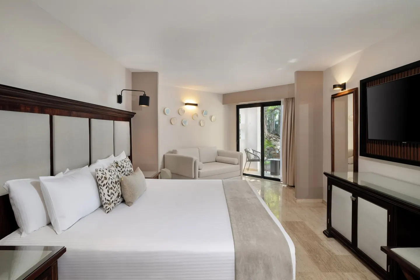 Junior Suite king bed with sofa and terrace doors at Grand Palladium Vallarta Resort & Spa.