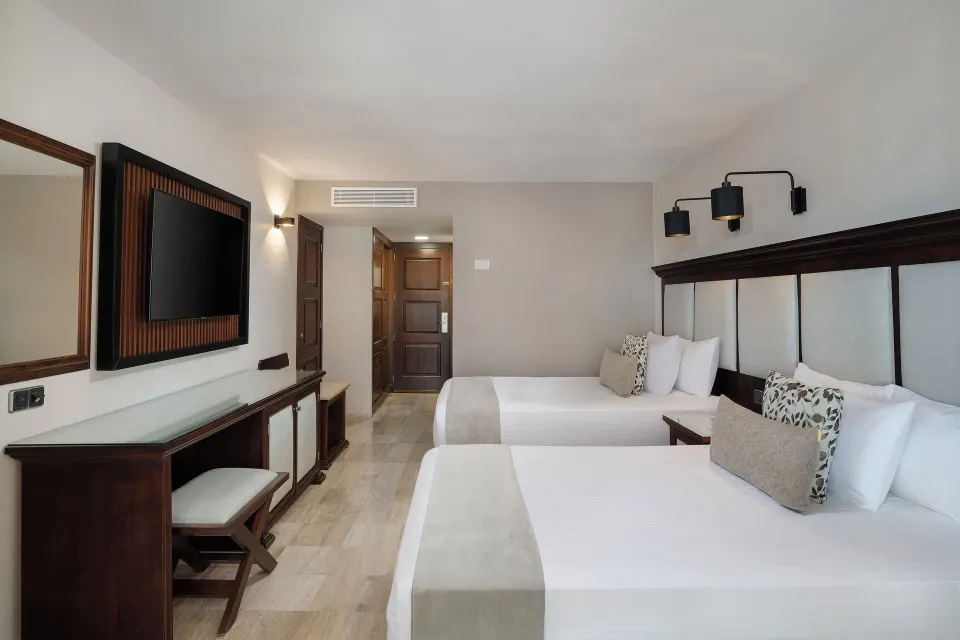 Junior Suite with two beds and wall-mounted TV at Grand Palladium Vallarta Resort & Spa.