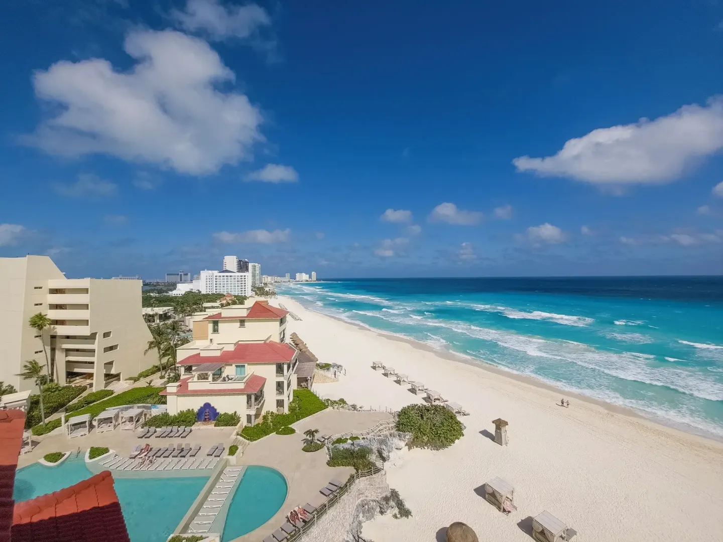 Aerial coastline view with pool, beach, and ocean at Grand Park Royal Cancun.