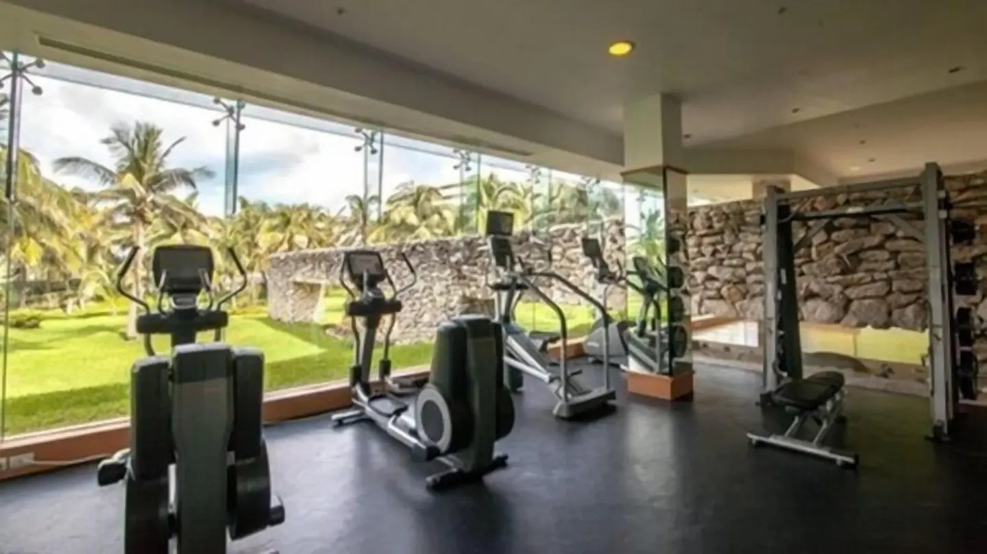 Fitness room with cardio machines and garden views at Grand Park Royal Cancun.