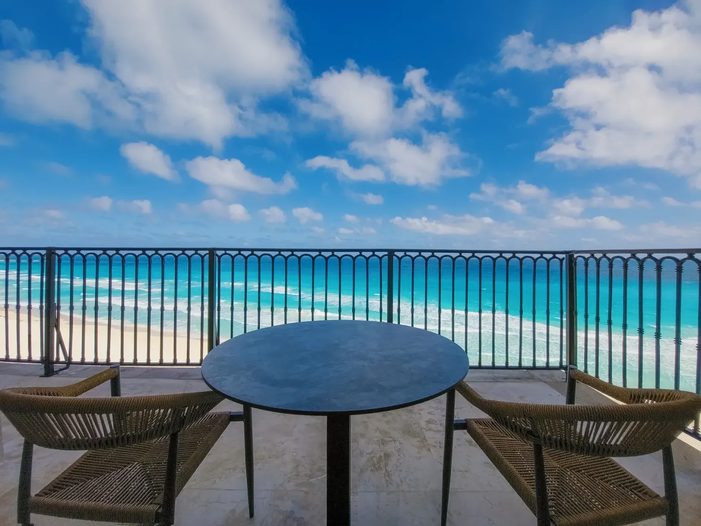 Balcony table and chairs overlooking the beach at Grand Park Royal Cancun.
