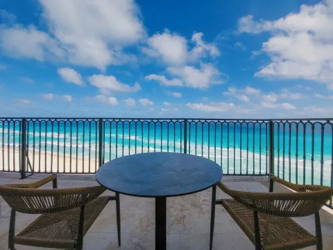 Balcony table and chairs overlooking the beach at Grand Park Royal Cancun.