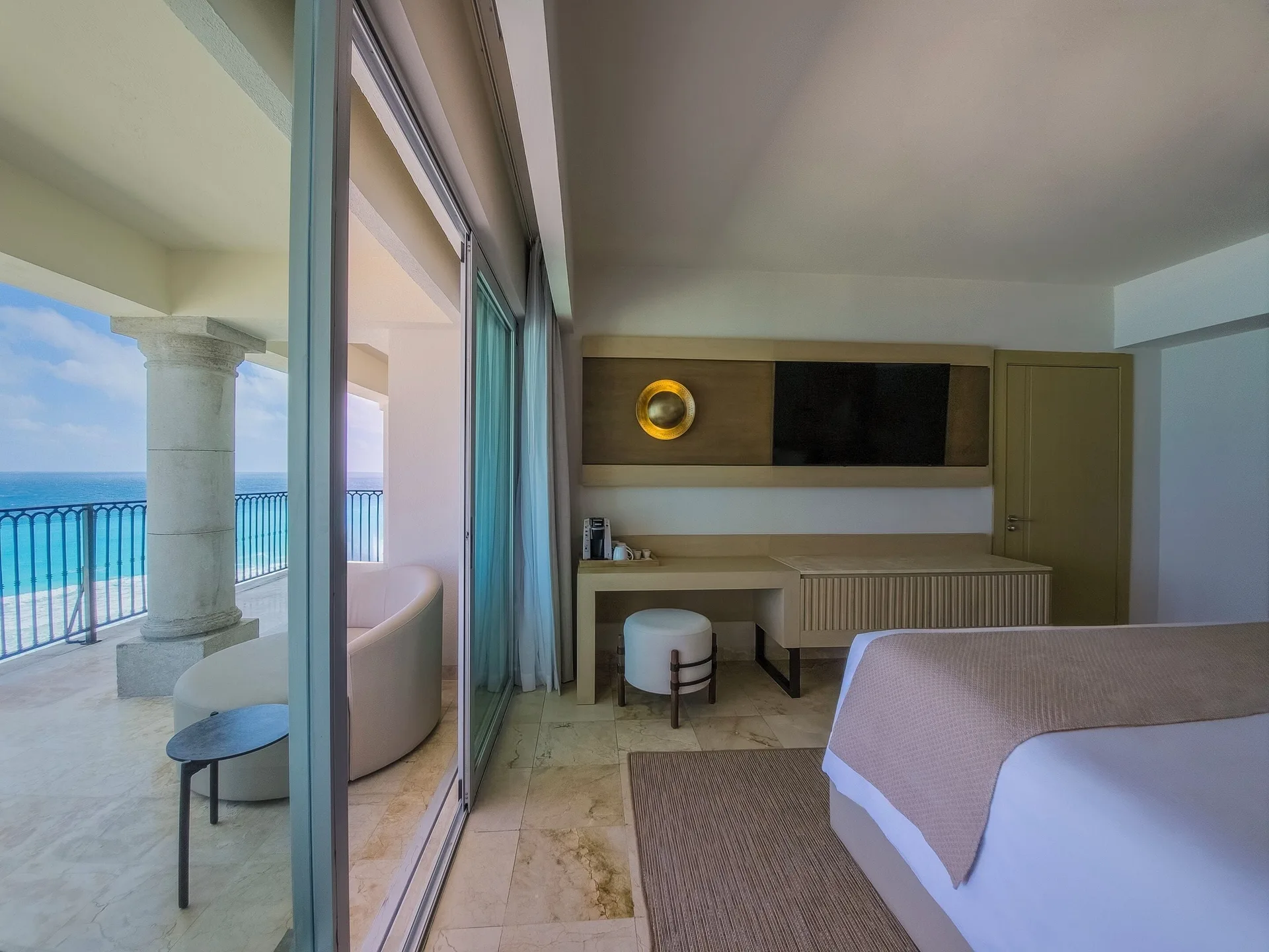 Guest room balcony and desk area with ocean view at Grand Park Royal Cancun.