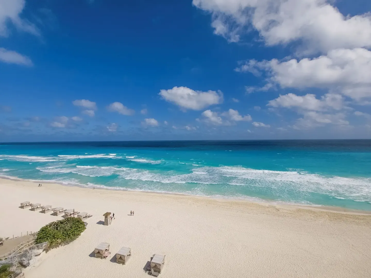 Wide view of white sand beach and turquoise surf at Grand Park Royal Cancun.